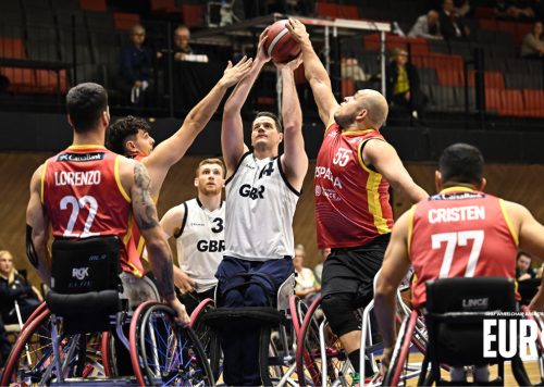 A group of people playing wheelchair basketball.