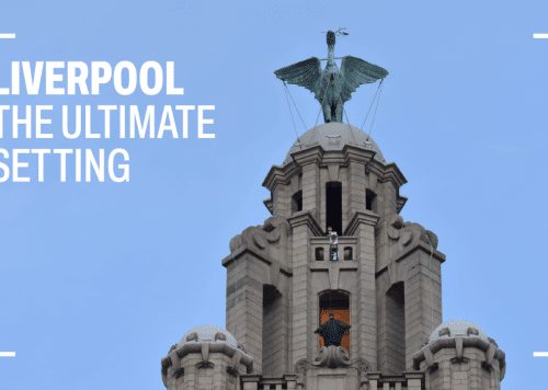 A photo of the top of the Royal Liver Building with someone dressed at The Batman standing at the top during a film shoot.