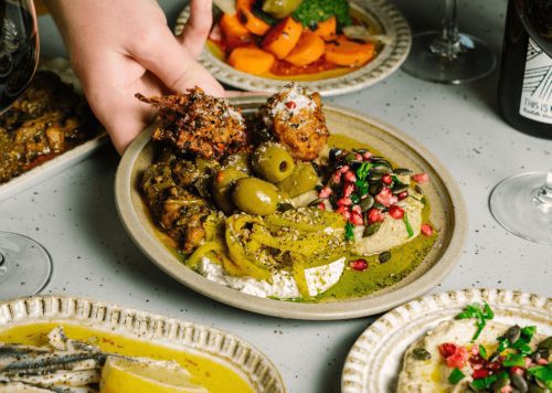 A table with a range of plates on it with food on them.