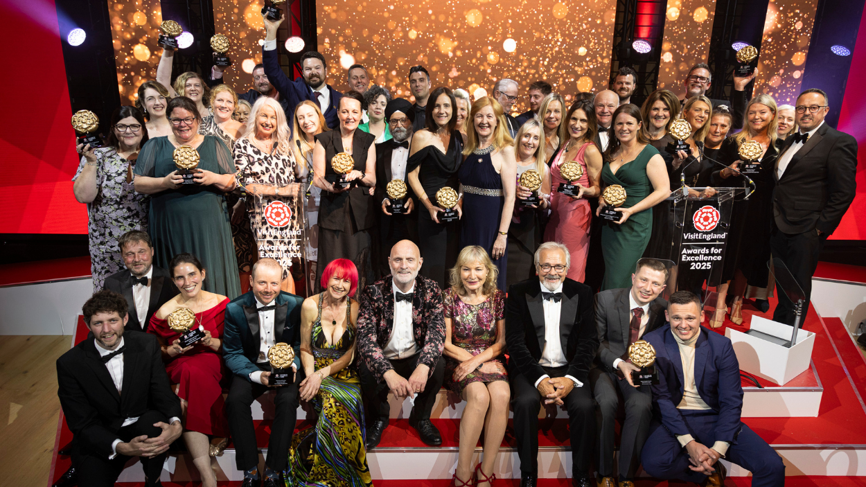 a large group of people at an awards show holding their awards.