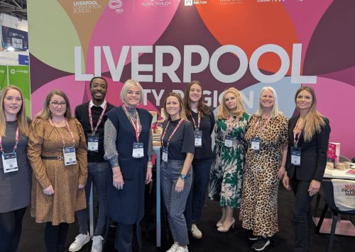 A group of people at a conference stand which says Liverpool city Region.