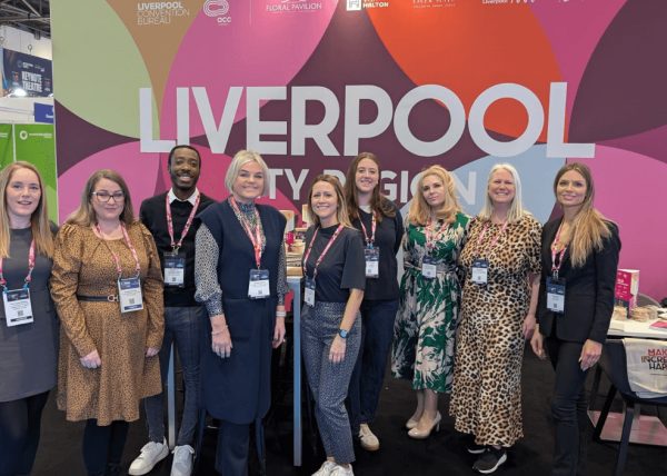 A group of people at a conference stand which says Liverpool city Region.
